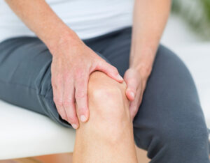 Photo of a man grabbing his knee in pain